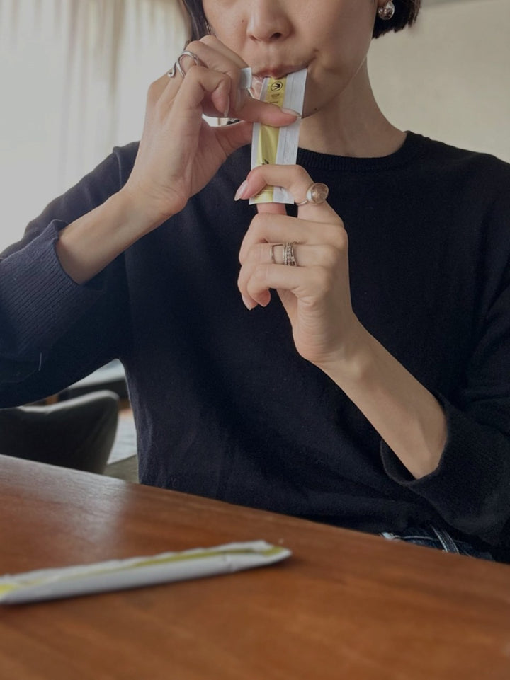 A woman taking a BI-SU jelly stick at her table