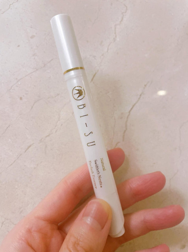 The BI-SU eyelash essence held over marble